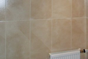 Gäste WC-Raum mit beigen Wandfliesen