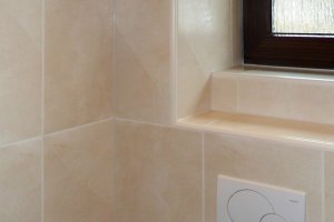 WC-Raum mit senkrechten Wandfliesen und Bordüre