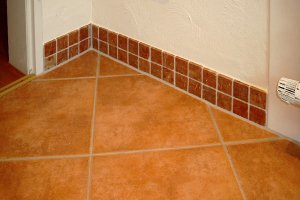 Boden in Cotto-Optik und Sockel aus Rosso Verona Mosaik