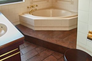 Feinsteinzeugfliesen in Holzoptik mit Stufe im Bad